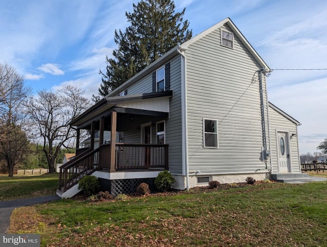 view of side of home with a lawn and covered porch