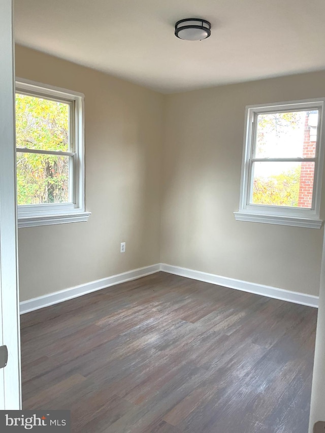 unfurnished room with dark wood-type flooring