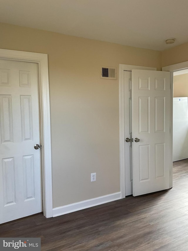 unfurnished bedroom with dark wood-type flooring