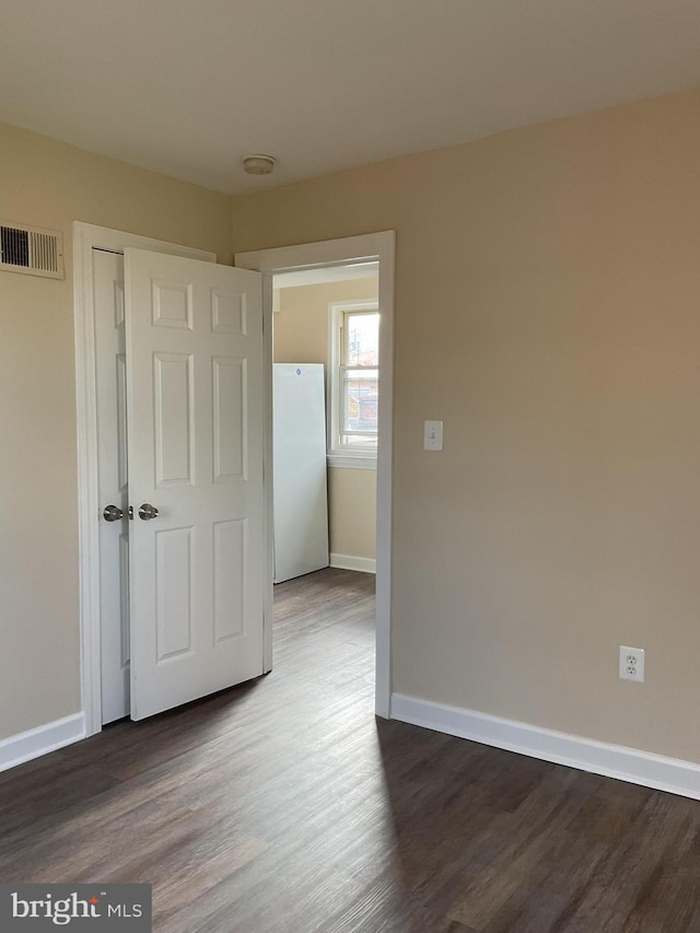 spare room featuring dark wood-type flooring