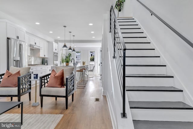 staircase featuring hardwood / wood-style flooring and sink