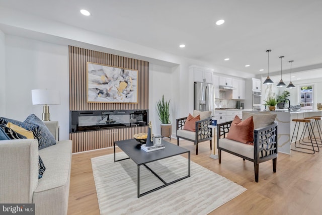 living room with light wood-type flooring and sink