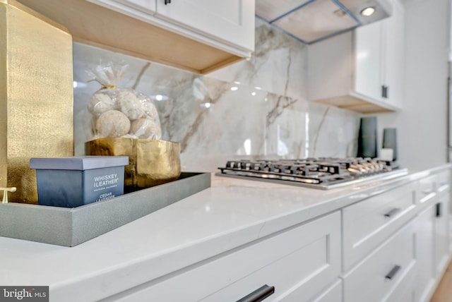 kitchen featuring white cabinets, backsplash, extractor fan, and stainless steel gas stovetop