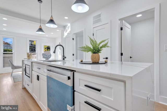 kitchen with sink, stainless steel appliances, light stone counters, pendant lighting, and white cabinets