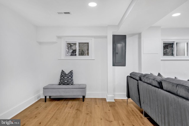 living area featuring electric panel and light hardwood / wood-style flooring