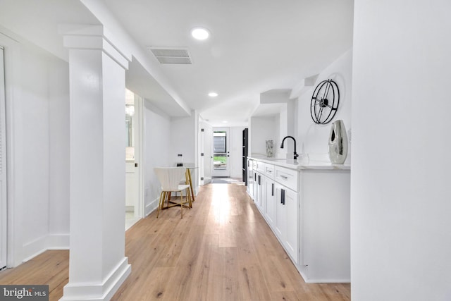 hallway featuring light wood-type flooring and sink