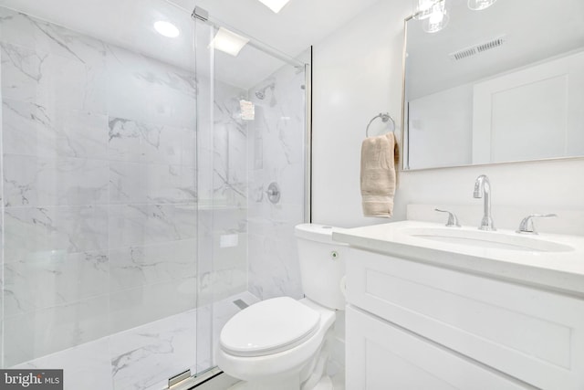 bathroom with vanity, a shower with shower door, and toilet