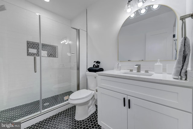 bathroom with tile patterned floors, vanity, toilet, and a shower with door