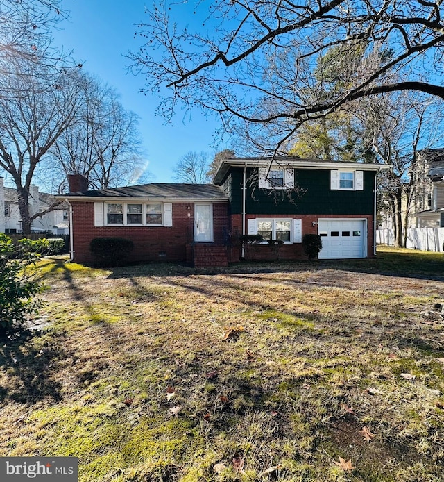 split level home with a garage and a front lawn