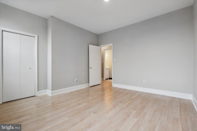 unfurnished bedroom featuring light hardwood / wood-style floors and a closet