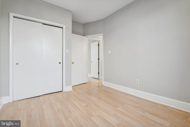 unfurnished bedroom with a closet and light hardwood / wood-style flooring