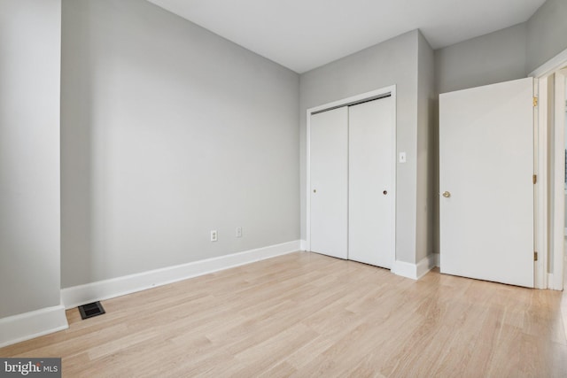 unfurnished bedroom with light hardwood / wood-style flooring and a closet