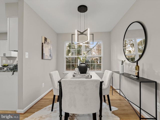 dining area featuring a notable chandelier, light hardwood / wood-style floors, and a wealth of natural light