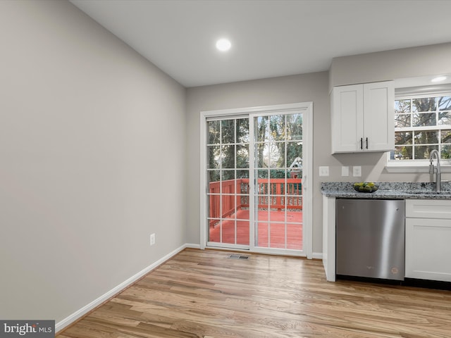 kitchen with white cabinetry, light hardwood / wood-style flooring, stainless steel dishwasher, and sink