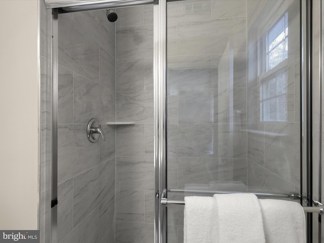 bathroom featuring a shower with door