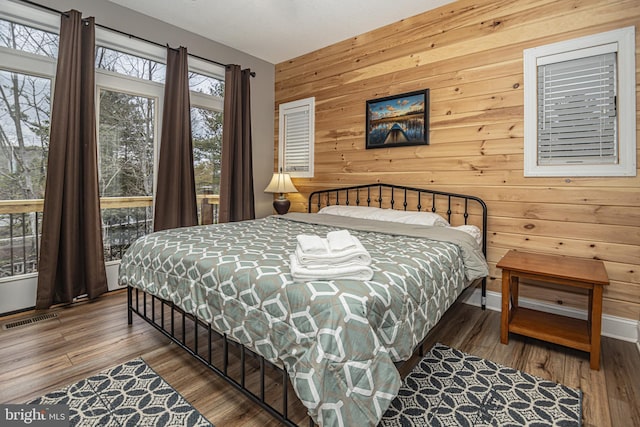 bedroom featuring wood-type flooring and wood walls