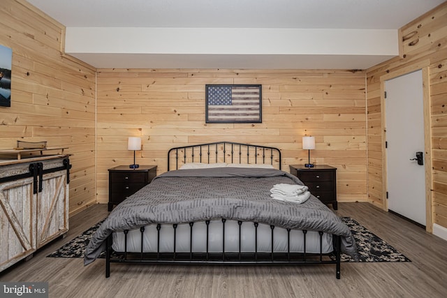 bedroom featuring hardwood / wood-style flooring and wood walls