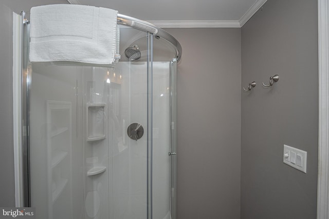 bathroom featuring a shower with door and ornamental molding