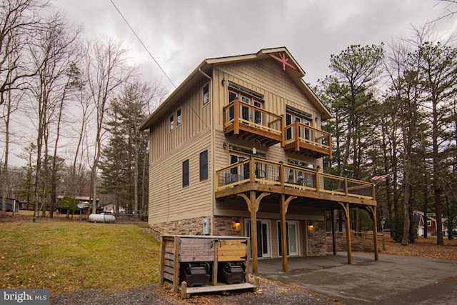 exterior space featuring a patio area, a deck, and a front lawn