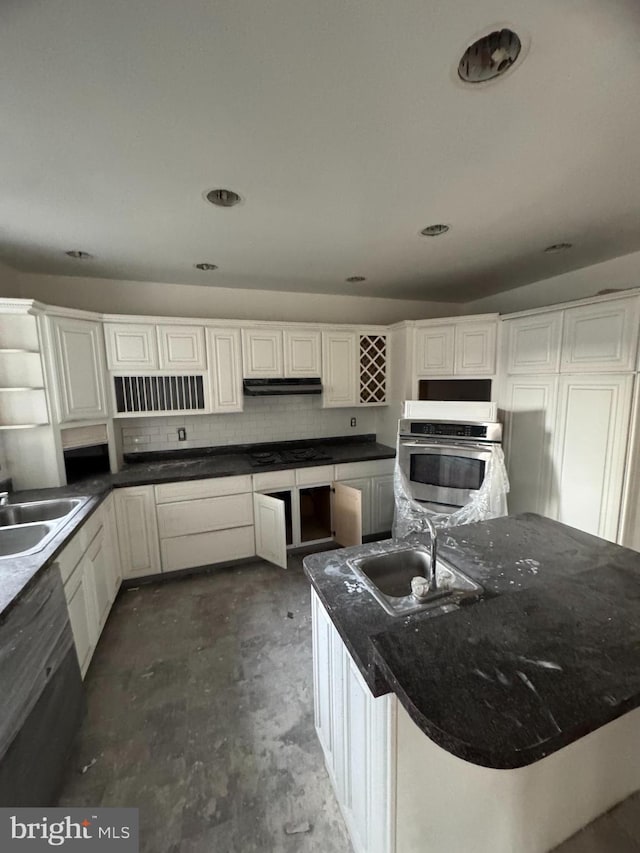 kitchen with tasteful backsplash, white cabinetry, sink, and black appliances