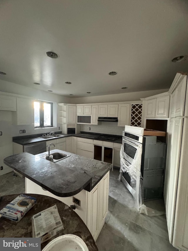 kitchen featuring a center island, white cabinetry, sink, and gas cooktop