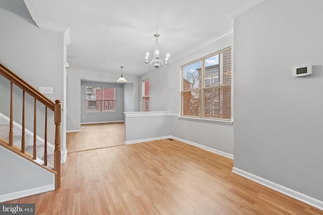 unfurnished dining area with ornamental molding, light wood-type flooring, and a notable chandelier