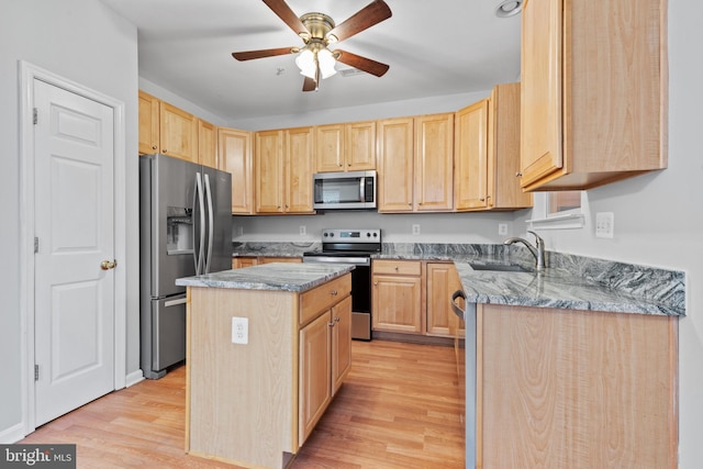 kitchen with sink, a center island, light brown cabinets, appliances with stainless steel finishes, and light wood-type flooring