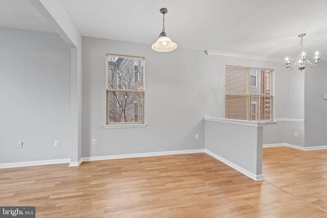 unfurnished dining area featuring light hardwood / wood-style floors, an inviting chandelier, and ornamental molding