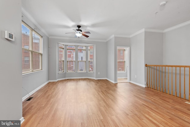 unfurnished room with ceiling fan, a healthy amount of sunlight, light wood-type flooring, and crown molding