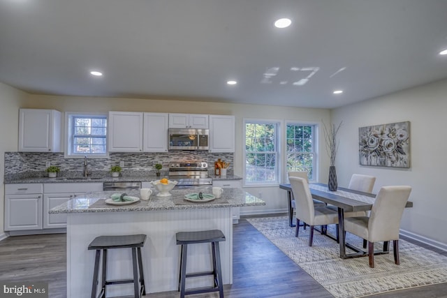 kitchen with white cabinets, plenty of natural light, a center island, and stainless steel appliances