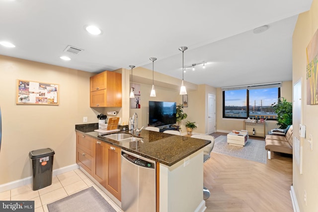 kitchen with sink, hanging light fixtures, stainless steel dishwasher, dark stone countertops, and kitchen peninsula