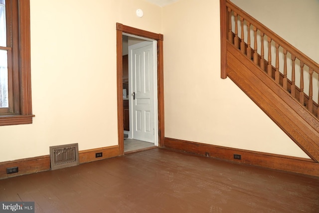 unfurnished room with dark wood-type flooring