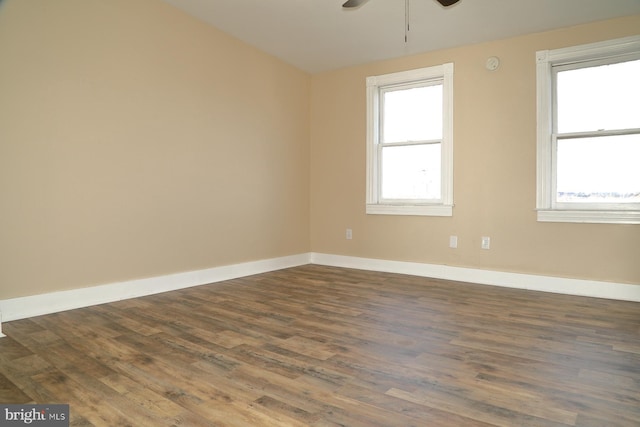 spare room with ceiling fan, a healthy amount of sunlight, and dark hardwood / wood-style flooring