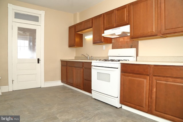 kitchen with backsplash, sink, and white gas range oven