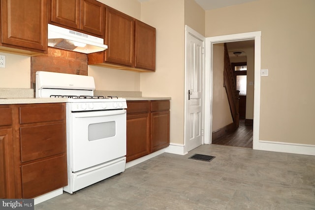 kitchen with light hardwood / wood-style floors, white range with gas stovetop, and tasteful backsplash