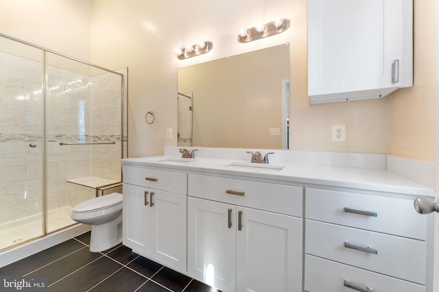 bathroom with a shower with shower door, toilet, vanity, and tile patterned flooring