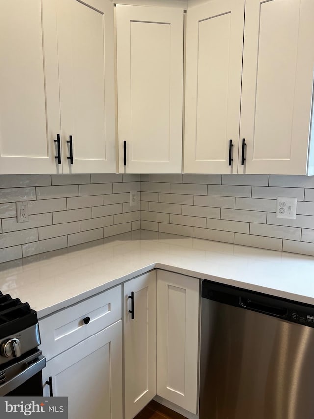 kitchen with white cabinets, backsplash, stainless steel appliances, and light stone counters