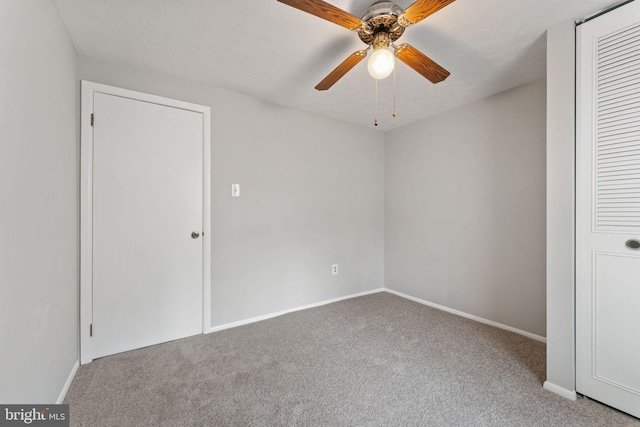 unfurnished bedroom featuring carpet, a textured ceiling, and ceiling fan