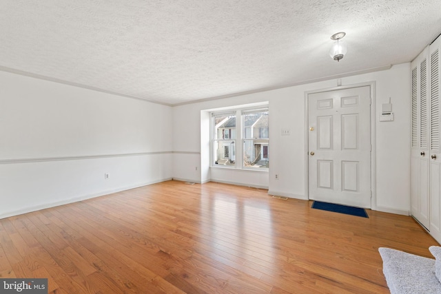 entrance foyer with light hardwood / wood-style flooring and a textured ceiling