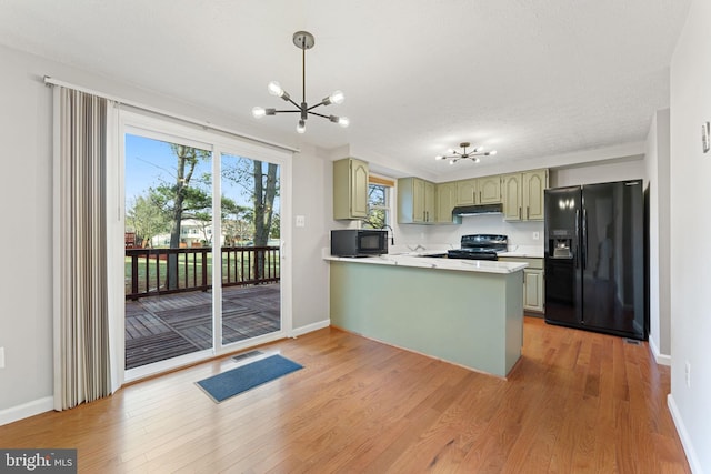 kitchen featuring kitchen peninsula, black appliances, a chandelier, hanging light fixtures, and green cabinets