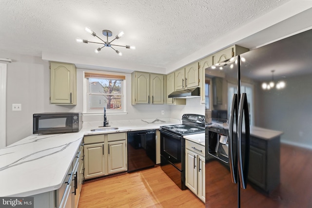 kitchen with sink, green cabinets, light hardwood / wood-style floors, a textured ceiling, and black appliances