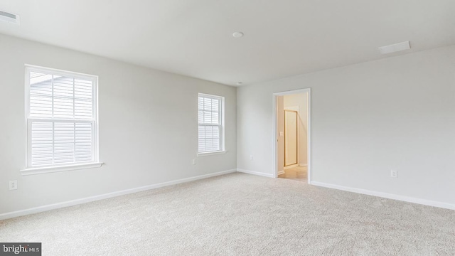 spare room featuring light colored carpet