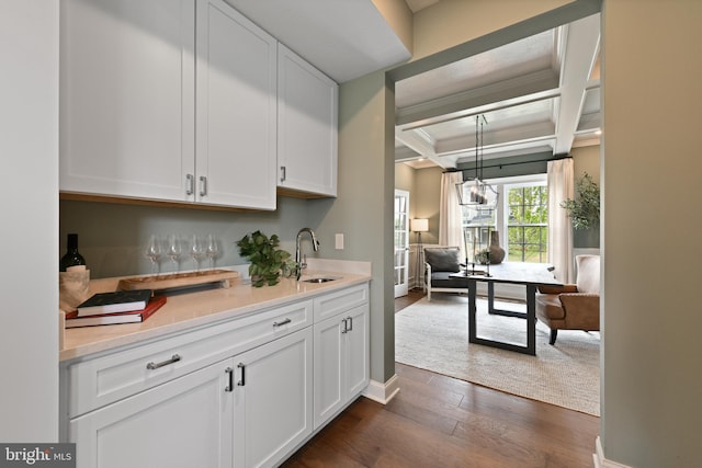 bar featuring white cabinets, beamed ceiling, dark wood-type flooring, and sink