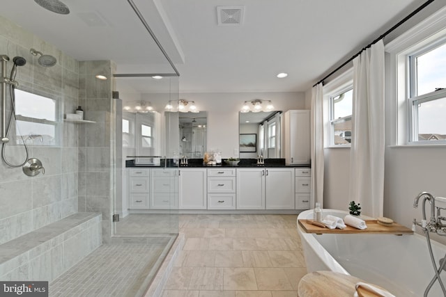 bathroom with tile patterned flooring, vanity, and shower with separate bathtub