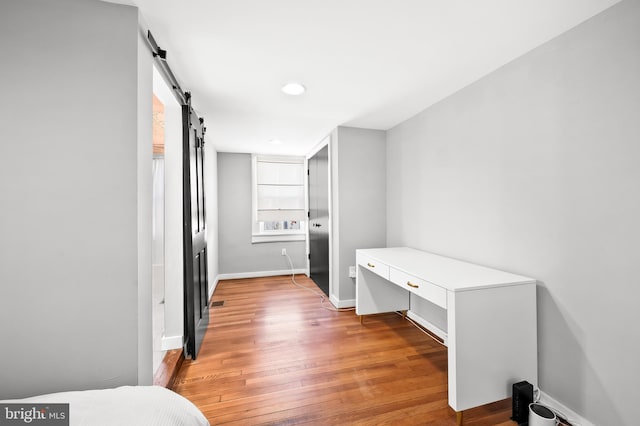 interior space featuring a barn door and wood-type flooring