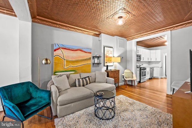 living room with light wood-type flooring and crown molding