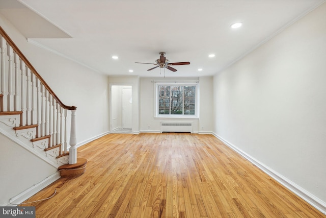 unfurnished living room with radiator heating unit, light hardwood / wood-style flooring, ceiling fan, and crown molding