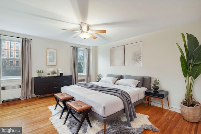 bedroom featuring light hardwood / wood-style floors, radiator, and ceiling fan