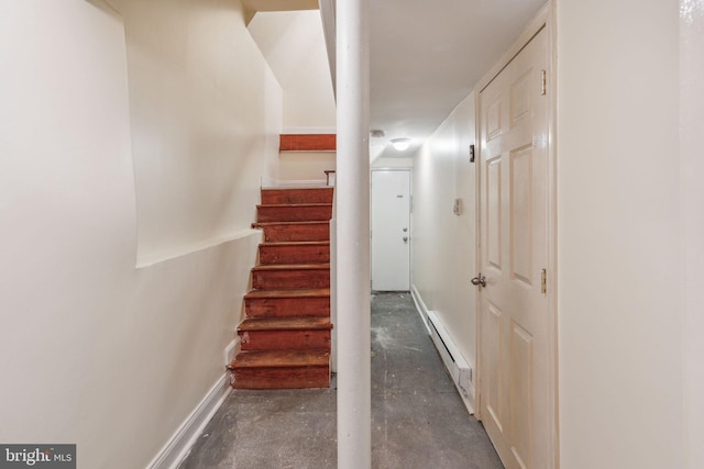 staircase featuring concrete floors and baseboard heating