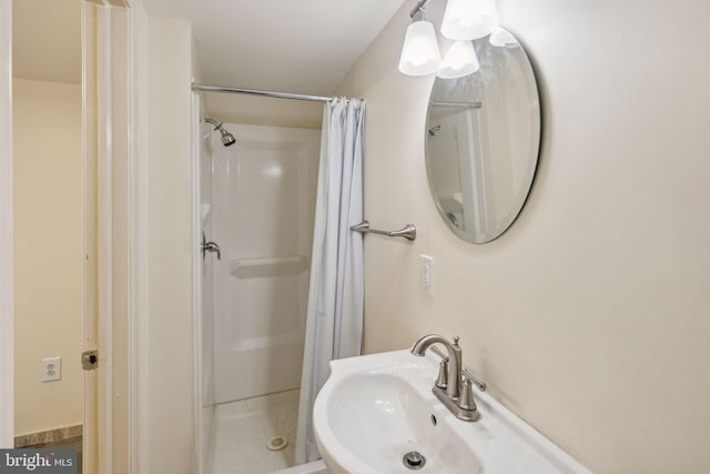 bathroom with a shower with shower curtain and sink